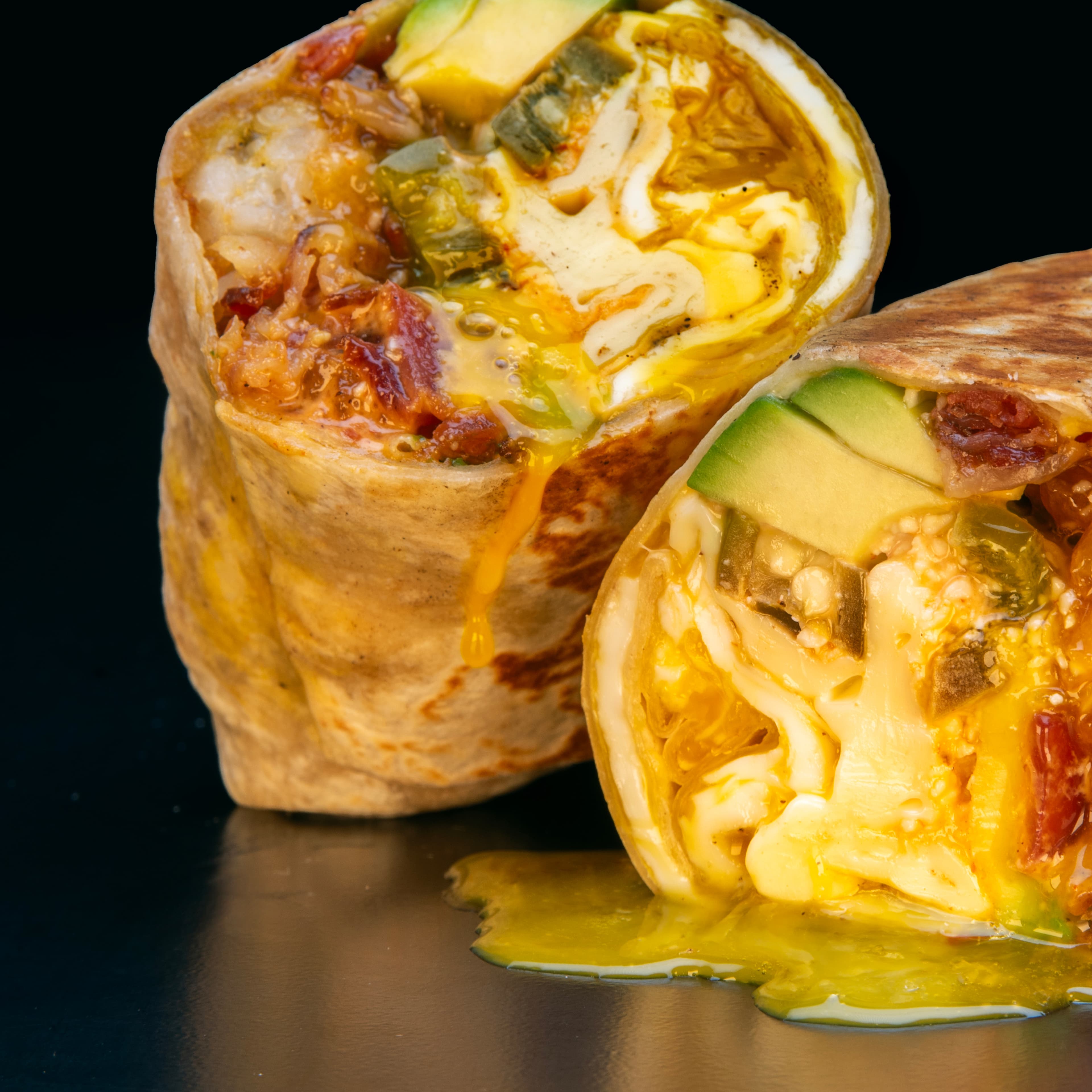 Breakfast burrito with avocado, eggs, and melted cheese
